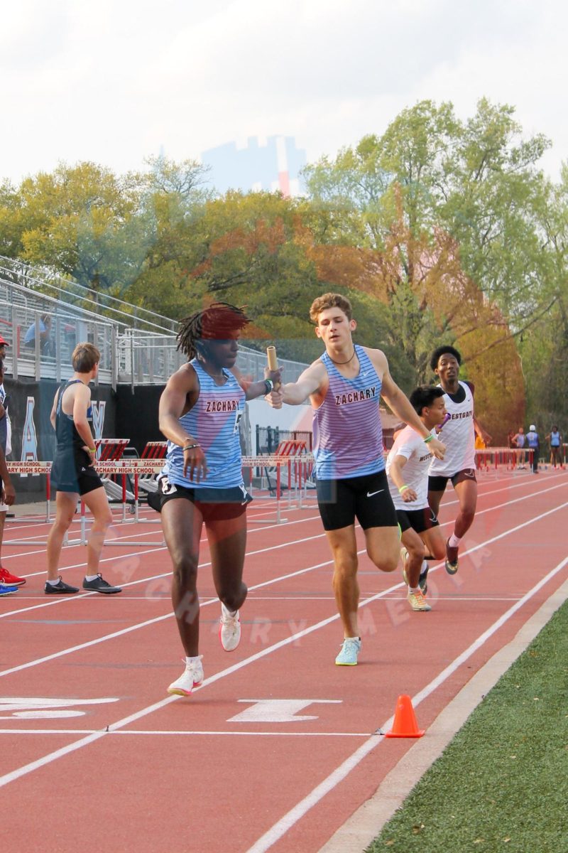 Conner Conahan (10) passes the baton to Noah George (11), in the 4x800 relay.