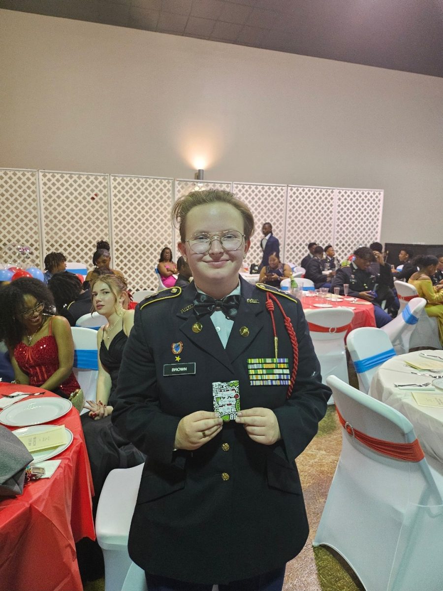 Tyler Brown (12) is gifted a $50 Raising Canes gift card, from Colonel Spears, for assisting in decorating the Military Ball.