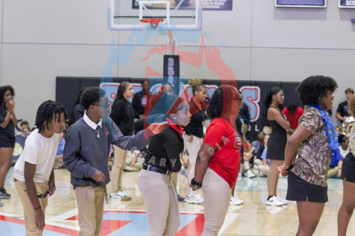 Students line up to play a game of dance telephone. The student at the start of the line danced a move and the students behind them had to replicate the dance.