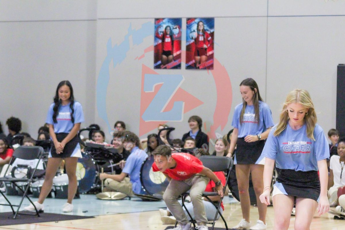 The student classes compete at a game of balloon pop while running back and forth on the basketball court. 