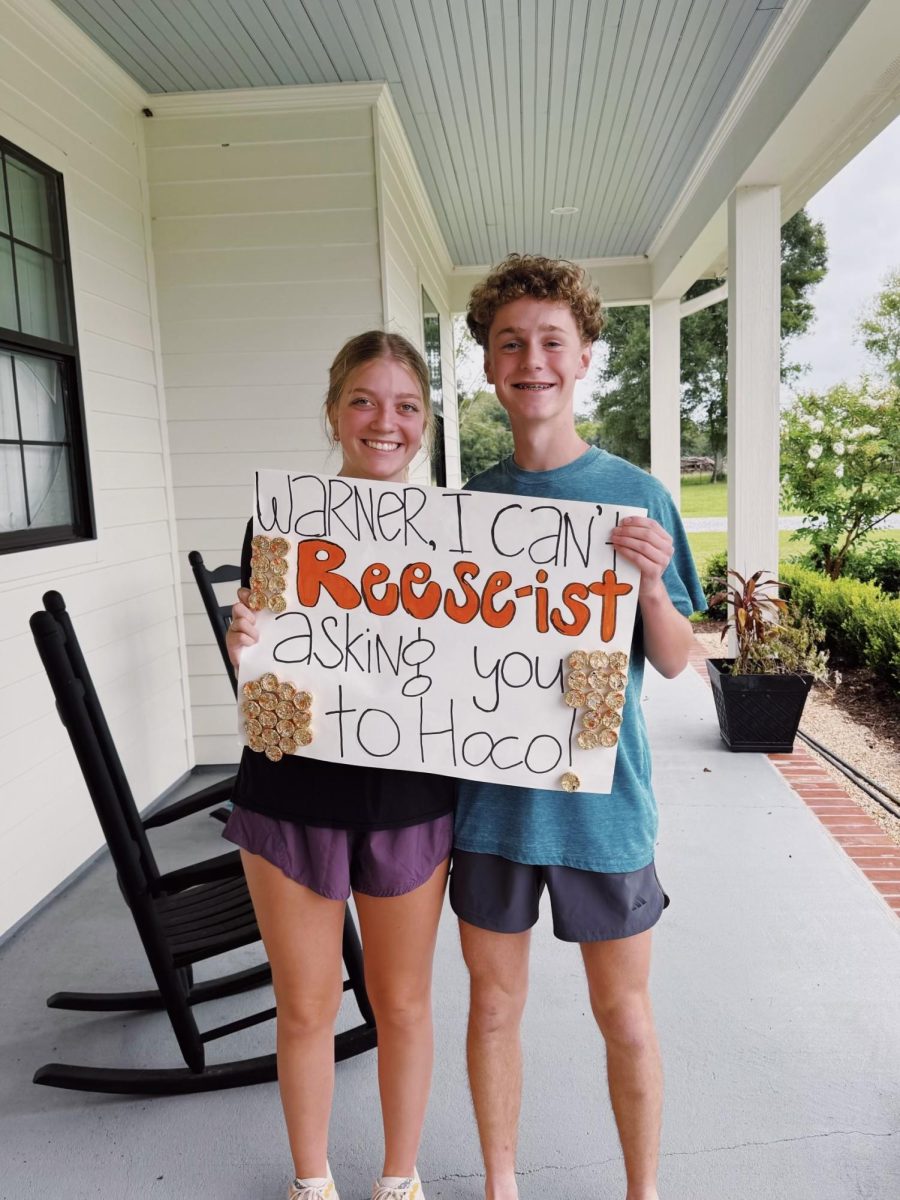 Meriweather Wren (12) and Warner Barron (9) stand outside Barron's home with the sign Wren made for him. They were both extremely excited to go to the dance together!