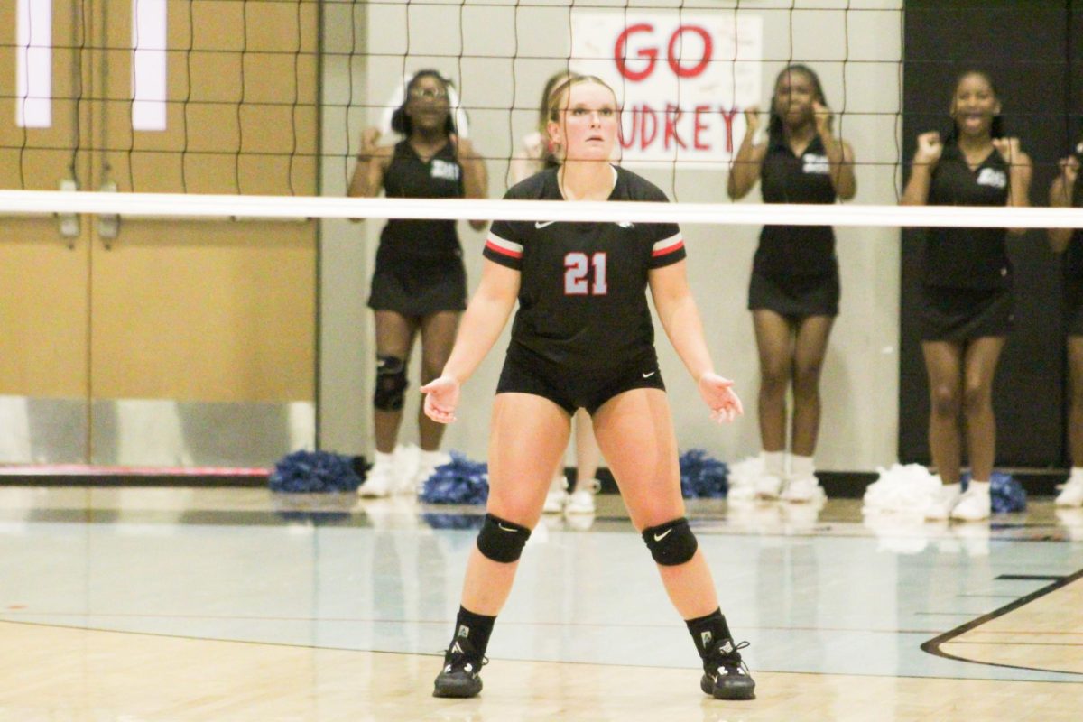 Audrey Mitchem (12) gets ready for a Port Allen serve. Mitchem, the captain, was a leading player throughout the night and had great success in leading the broncos to a win in straight sets.