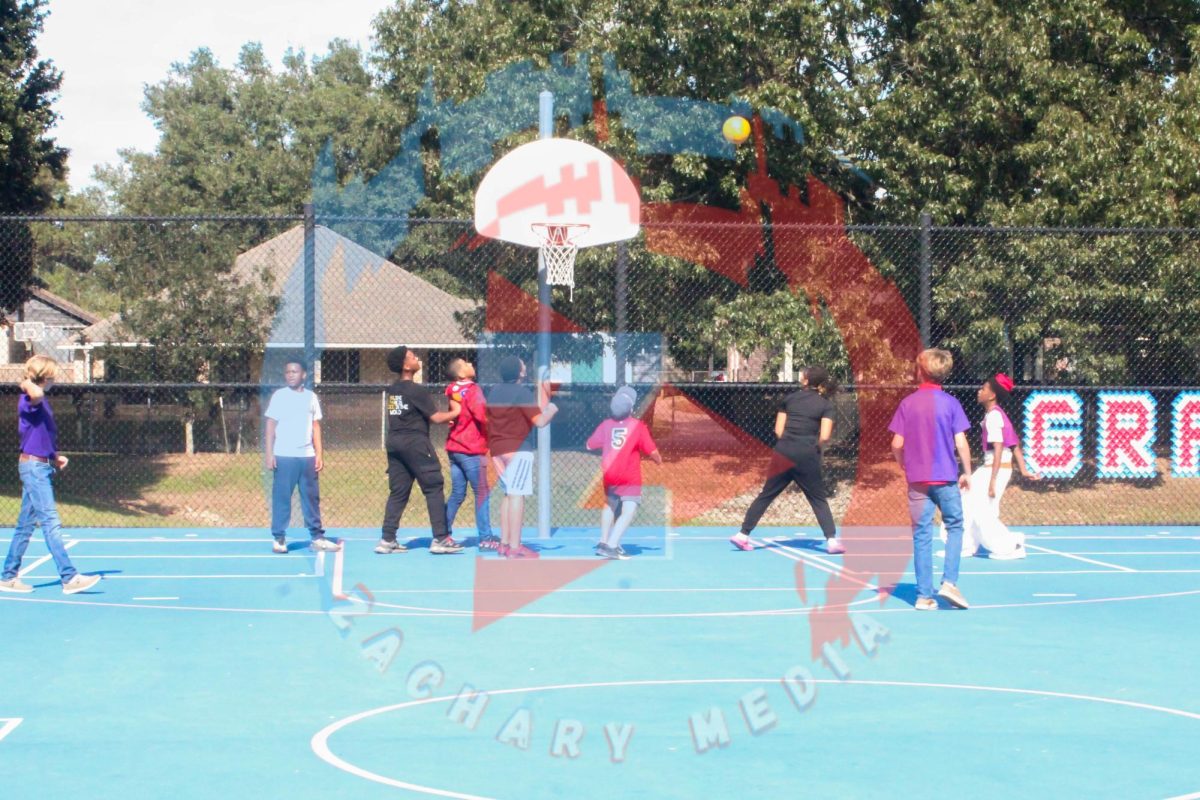 Kids play a game of basketball on the court.