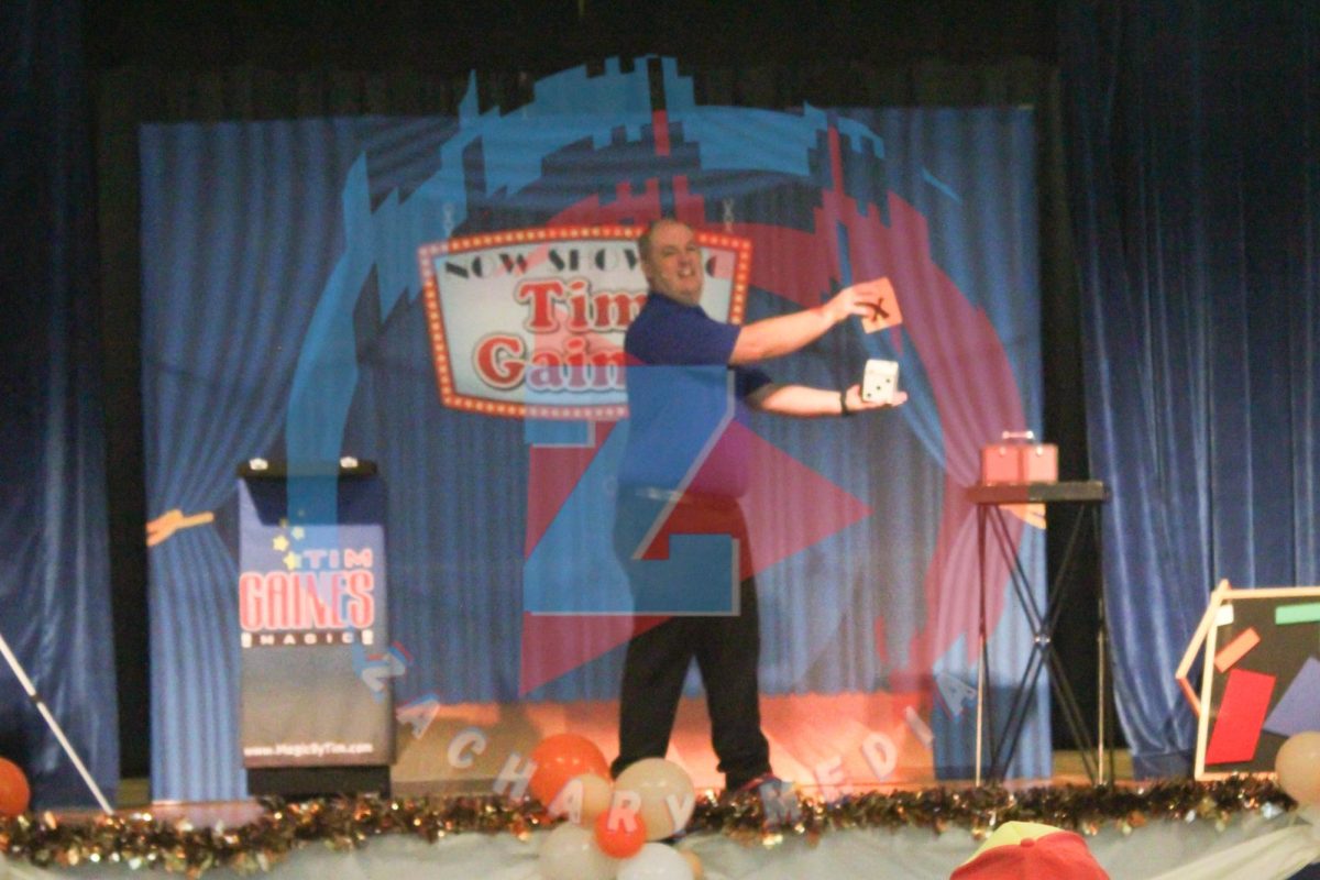 Tim Gaines performs on the stage, showing off his magic tricks.