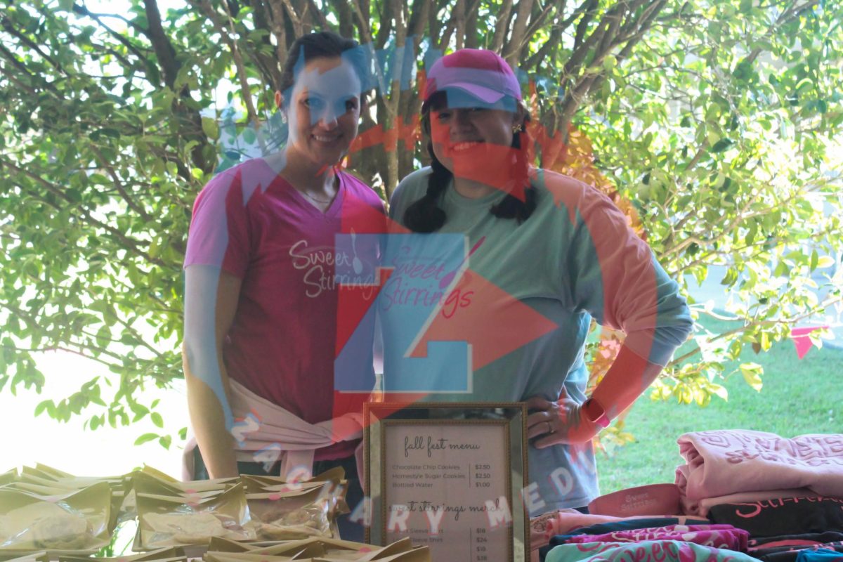 Sweet Stirrings poses behind their table, where they're selling cookies and sweat treats!