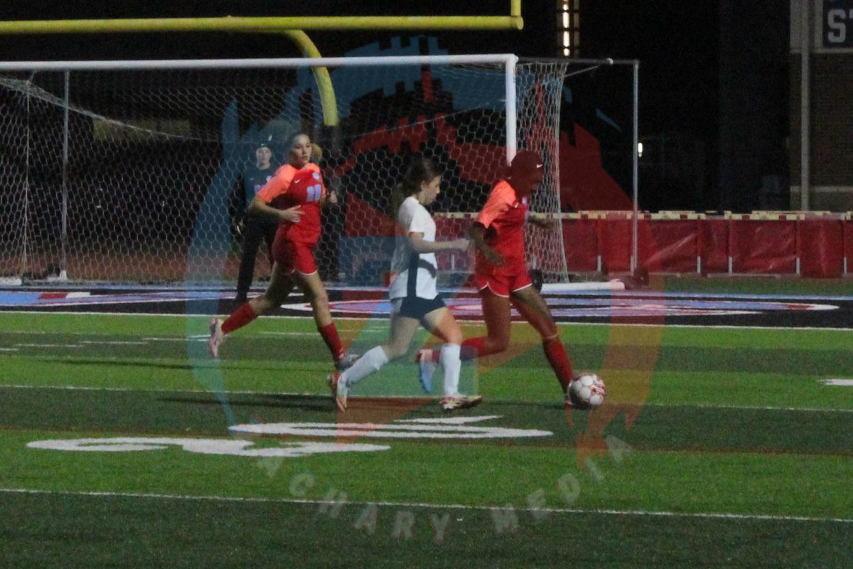 Yasmin Batchelor (12) desperately tries to keep her opponent from getting the ball,