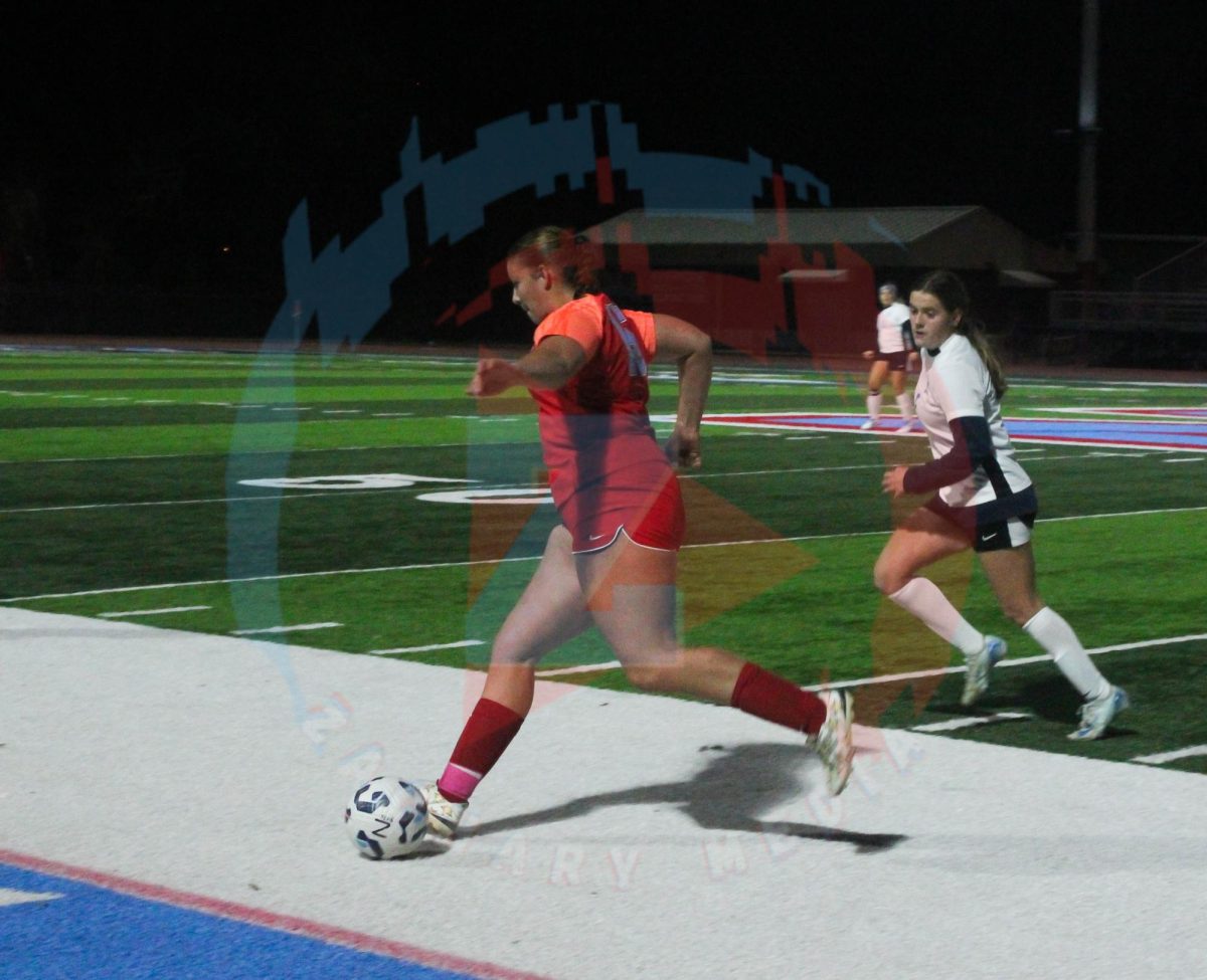 Emily Maas (12) races her opponent to maintain control of the ball.