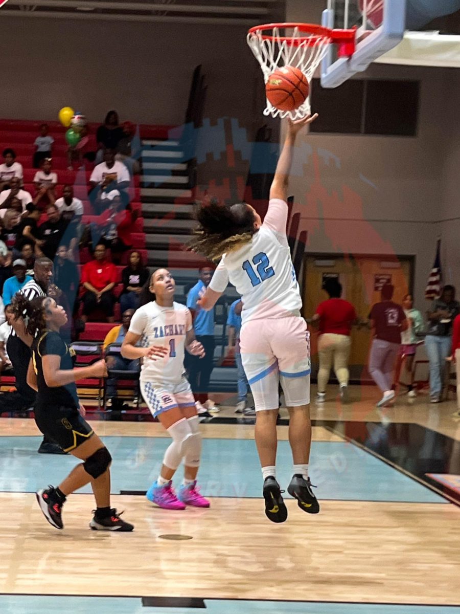 Ayja Walker (10) jumping up to lay up the ball into the basket.