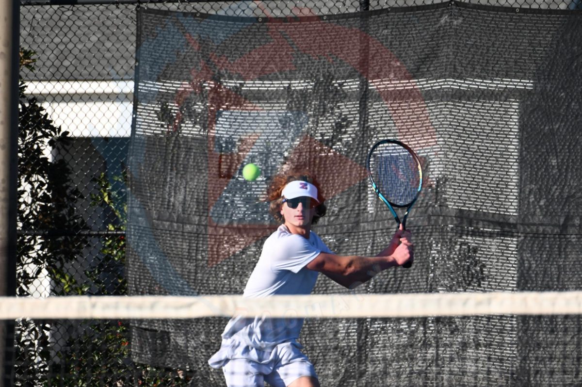 Clayton Howell (12) hits the ball back to his opponent. Howell won his match against the Prairieville player.