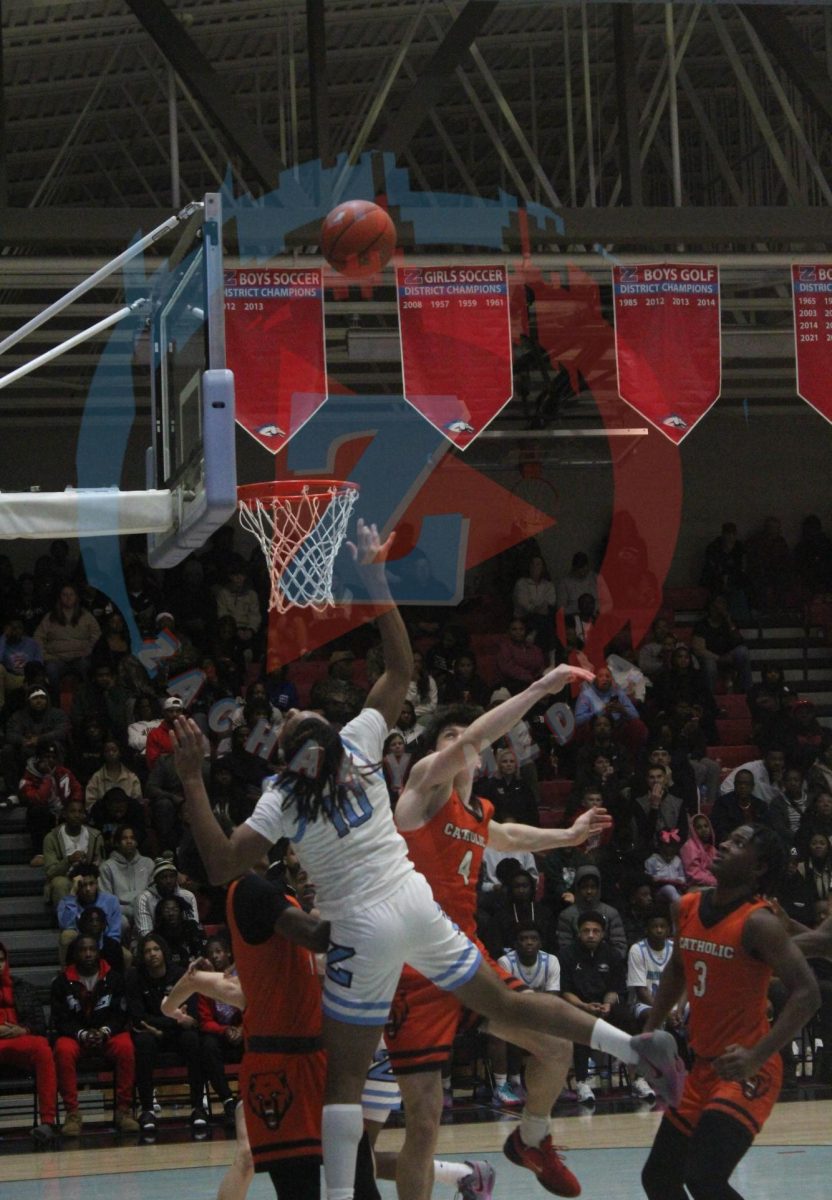 Xavier Ferguson (12), surrounded by Catholic defenders, shoots a contested shot.