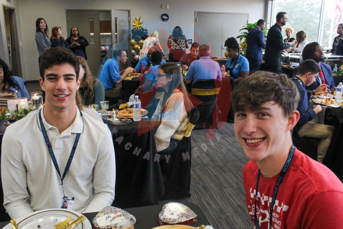 Ethan Nelson (12) and Rafael Costa (12) sit together at the ACT brunch. 