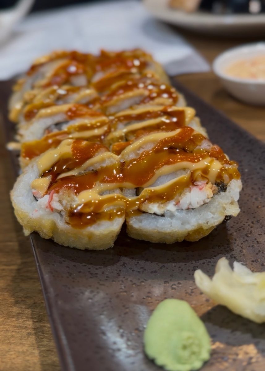 The LSU roll which is made of Crawfish, crab meat, shrimp tempura, cream cheese, deep fried, topped with spicy sauce, siracha and finally sushi sauce.